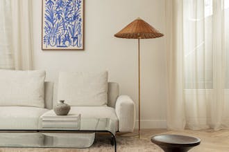 A neutral living room scheme with beige sofa and off-white (Portland Stone) painted wall featuring a blue and white painting.