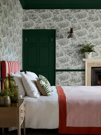 Bedroom with dark green French Toile wallpaper (Lovers' Toile - Puck), dark green (Puck) door and ceiling and white bedding.