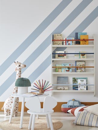 Child's reading corner painted in white (Shirting) with pale blue (Bone China Blue) diagonal stripes with a book shelf on the wall and a stuffed giraffe, table and chair.