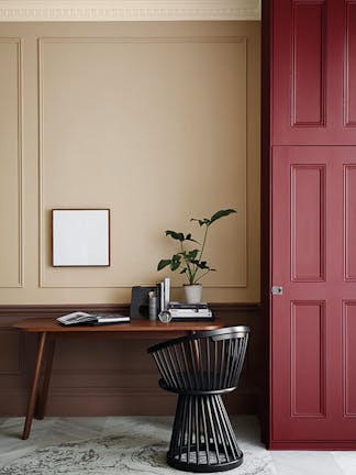 Warm neutral (Castell Pink) home study area with a red (Arras) door next to a wooden desk and chair.  