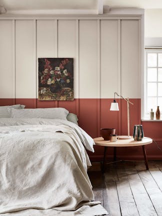 Bedroom with a light grey (French Grey) upper wall and a terracotta red 'Tuscan Red' lower wall behind a bed.