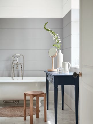 Bathroom painted in dark grey (Gauze - Dark) with a white bathtub and contrasting blue black (Basalt) side table.