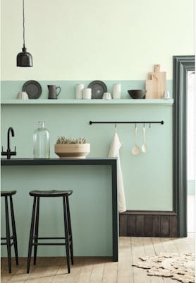 Kitchen space in varying shades of Aquamarine with a breakfast bar and stools on a wooden floor.