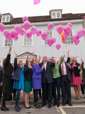 Little Greene & Breast Cancer Haven teams celebrating outside underneath pink balloons.