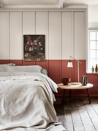 Bedroom with a light grey (French Grey) upper wall and a terracotta red 'Tuscan Red' lower wall behind a bed.