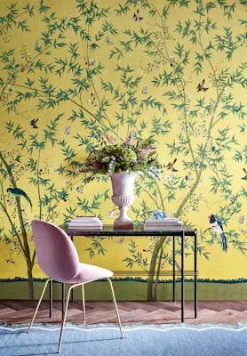 Home study with a bright yellow floral and bird wallpaper (Belton Scenic - Sunbeam) with a desk and chair placed in front.