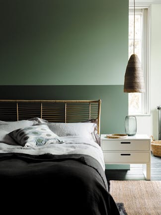 Bedroom with the upper wall painted in Aquamarine and the lower wall in Aquamarine - Pale with a double bed and side table.