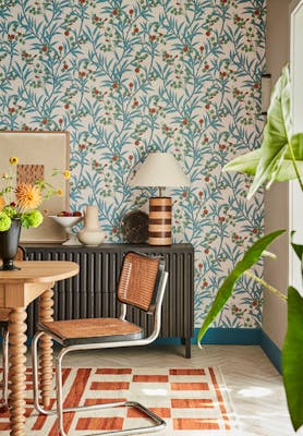 Dining space featuring blue and neutral floral wallpaper (Bamboo Floral - Heat) with a wooden dining table and chair.