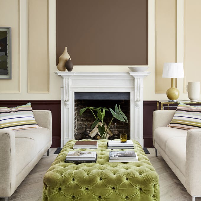 Sitting room with a neutral beige (Clay - Mid) wall and panelling in deep stone, pale brown and fawn colors, and two sofas.