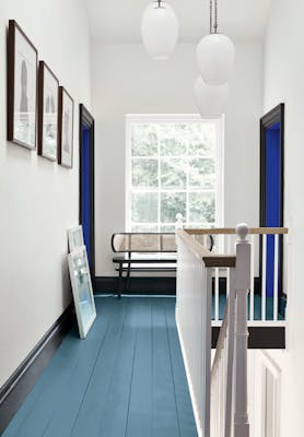 Hallway with an Air Force Blue painted floor, contrasting white (Shallows) walls and a window at the end of the corridor.