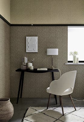 Indoor study with two shades of small scale wallpaper 'Moy' (Lime and Pompei) with a black desk and white chair.