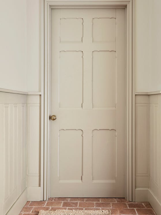 Hallway with a matching neutral (Portland Stone) door, dado rail and trim as well as upper walls in a lighter stone colour.