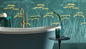 Bathroom with dark green (Harley Green) bath in front green floral mural wallpaper and yellow accents (Achillea - Aurora).