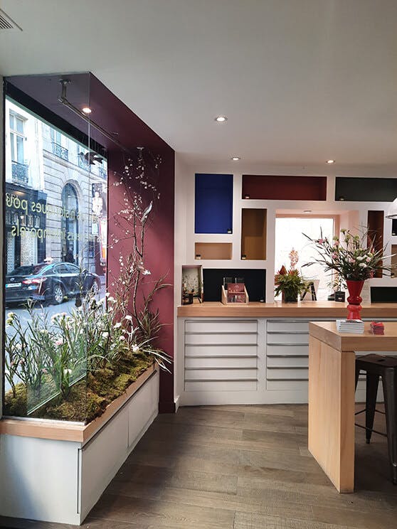 Inside view of the Little Greene Paris showroom window featuring birds, bees and flowers from the Bird & Bluebell wallpaper.