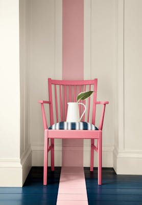 Dark pink (Carmine) chair with a dusky pink stripe painted from the wall down to the navy blue panelled floor.