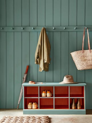 Paneled mudroom painted in green shade, Pleat, with contrasting deep red (Heat) shelving.