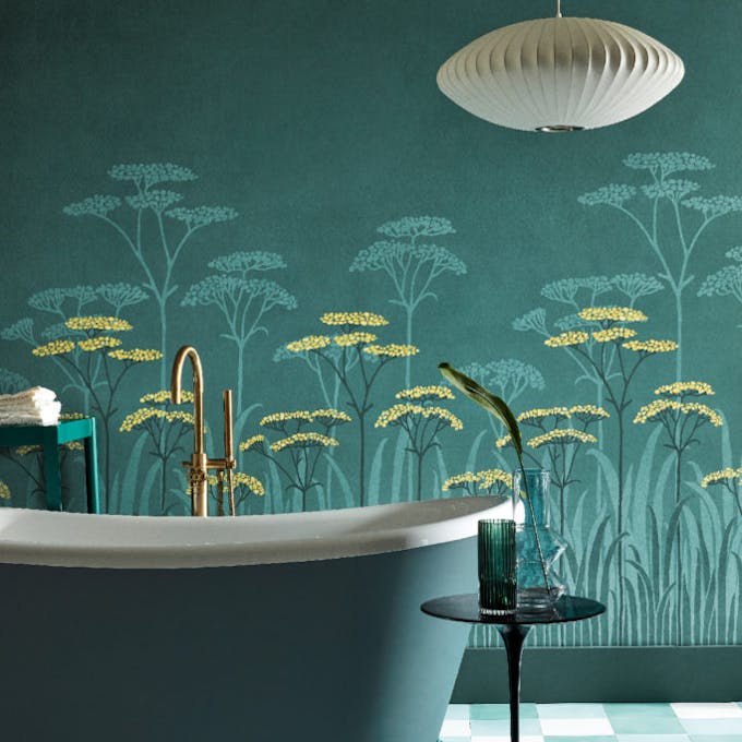 Bathroom with dark green (Harley Green) bath in front green floral mural wallpaper and yellow accents (Achillea - Aurora).