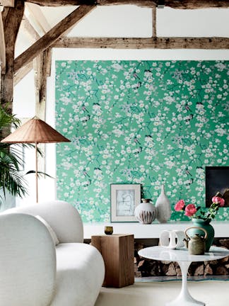 Living area with green printed floral and bird wallpaper (Massingberd Blossom - Verditer), cream sofa and ceiling beams.