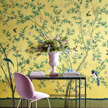 Home study with a bright yellow floral and bird wallpaper (Belton Scenic - Sunbeam) with a desk and chair placed in front.