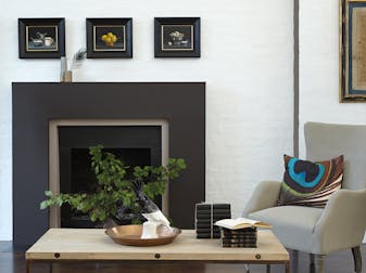 Pale grey living space with a deep grey mantelpiece and pale grey armchair