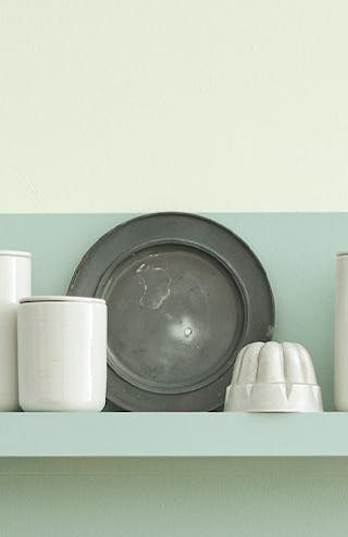 Close up of Kitchen space painted in varying shades of Aquamarine, featuring crockery on a display shelf