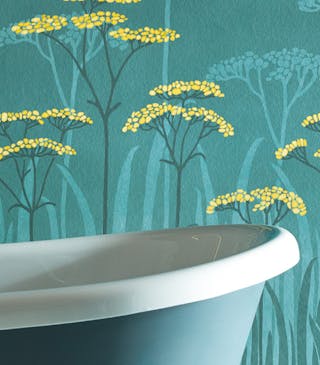 Bathroom with dark green (Harley Green) bath in front green floral mural wallpaper and yellow accents (Achillea - Aurora).