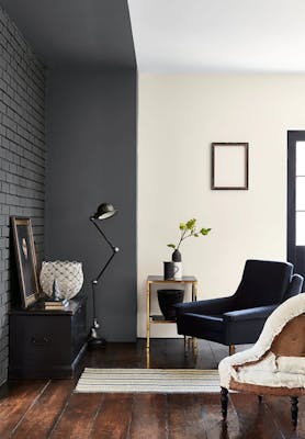 Living room with dark grey painted brickwork (Scree) with an off white wall and two armchairs facing a sidetable.