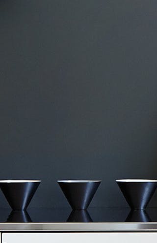 Black wall painted in Lamp Black behind a vintage flower painting, black bowls, fruit bowl and glass jar.