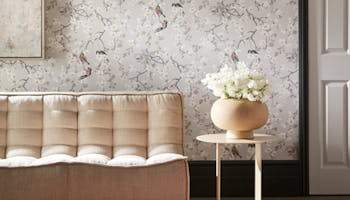 Living room featuring wallpaper with delicate tree branches, flowers and birds on a grey background (Massingberd – Grey).