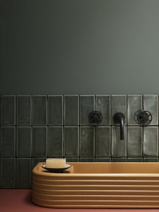 Tiled bathroom painted in grey-green shade 'Livid', with a contrasting wooden sink.