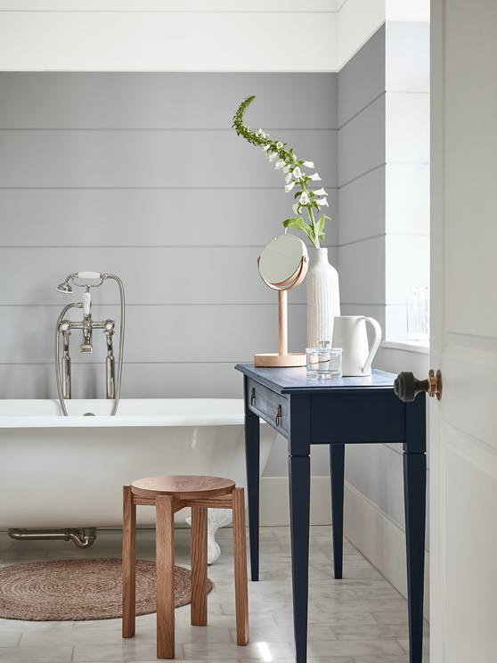 Bathroom painted in dark grey (Gauze - Dark) with a white bathtub and contrasting blue black (Basalt) side table.