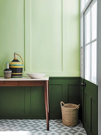 Paneled hallway with pale green (Acorn) upper wall and bold green (Hopper) lower wall with wooden sidetable and tiled floor.