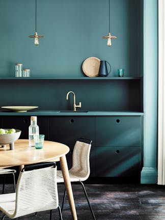 Kitchen painted in blue green (Tea with Florence) and dark green (Harley Green) with a round wooden table and chairs.