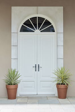 Front door entrance in bright white (Shirting) with matching surround and contrasting neutral back wall and two plant pots.