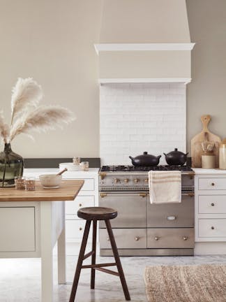 Country-style kitchen with neutral walls, white cabinets, stainless steel oven and a kitchen island.