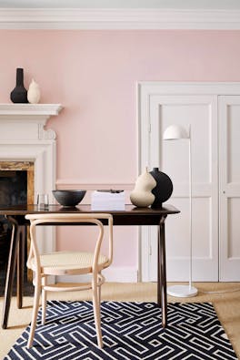 Home office with pale pink (Pink Slip) walls and contrasting neutral woodwork alongside a fireplace, wooden desk and chair.