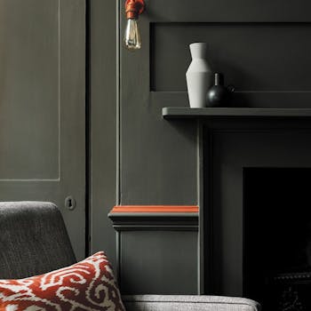 Living room color drenched in grey/ green shade 'Pompeian Ash' with a deep red contrast stripe and a grey sofa.