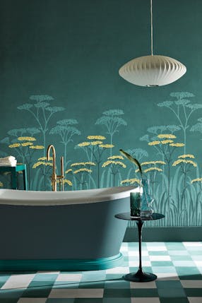 Bathroom with dark green (Harley Green) bath in front green floral mural wallpaper and yellow accents (Achillea - Aurora).