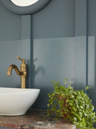 Cloakroom painted in muted blue shade 'Etruria' with a basin and a round mirror.