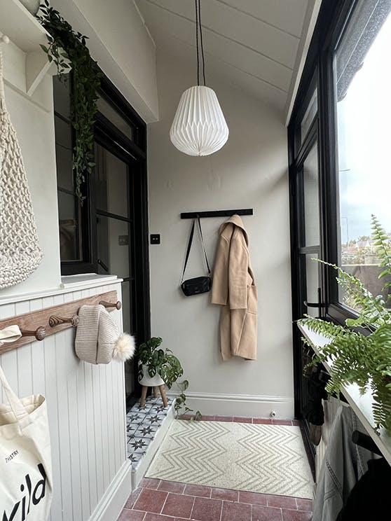 Home entrance with beige walls and paneling (Slaked Lime - Deep), alongside contrasting door and window frames in Jack Black.