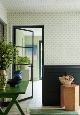 Hallway featuring green and grey small print floral wallpaper (Ditsy Block - Phthalo) with contrasting green woodwork and a stripy rug.