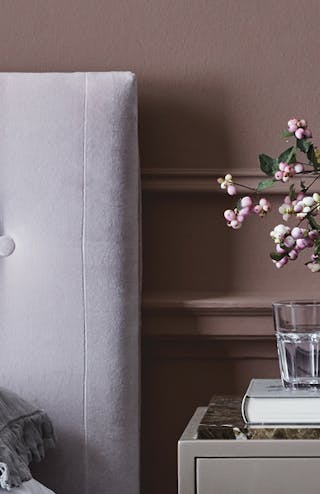 Nether Red bedroom with a French Grey - Dark door and drawers, topped with flowers, next to a bed with a grey headboard.