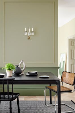 Dining space in neutral green 'Book Room Green' with a 'Sage Green' lower wall, and black dining room table and chairs.