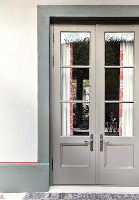 Exterior door painted in neutral grey 'Serpentine' with a pale grey 'Ceviche' wall and green 'Livid' trim.