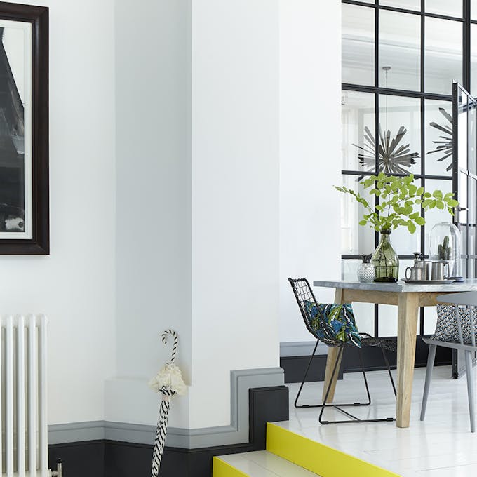 White stairs in a hallway with bright yellow (Trumpet) contrasting stair risers and a black and grey baseboard.