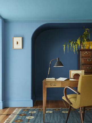 Bedroom painted in rich blue shade 'Royal Navy' with a bright blue 'Smalt' window frame, dark blue on the ceiling and a bed under the window.