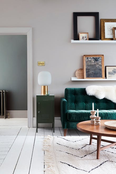 Velvet forest green sofa in front of a light grey (French Grey) wall and on top of bright white wood flooring in Loft White.