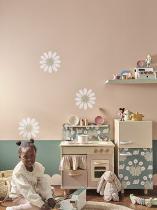 Playroom with pale pink (Masquerade) walls with a child playing with a toy cooker.