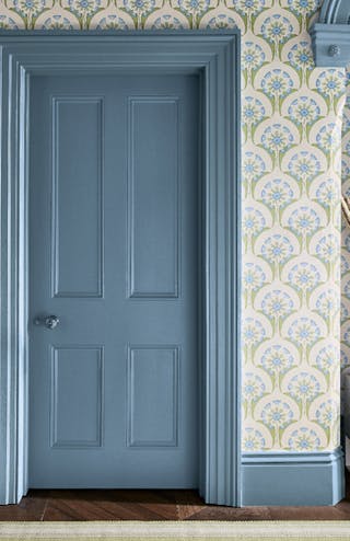 Hallway with blue and pink floral wallpaper (Hencroft - Blue Primula) and matching door and woodwork painted in blue grey.