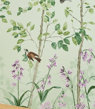 Close-up of green floral mural wallpaper featuring birds and butterflies (Bird & Bluebell - Pea Green).